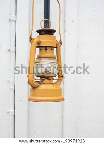 Street aged vintage kerosene oil lamp hanging outside