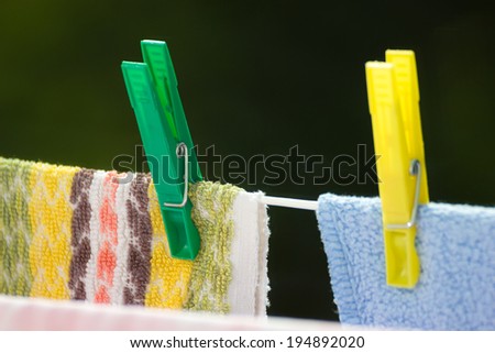 Housework. Clean wet laundry towels with clothespins hanging to dry on the line clothesline outdoor. Rural scene.