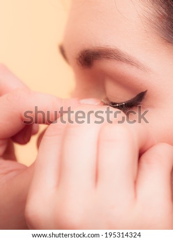 Closeup of female face. Brunette girl and insertion false eyelashes. Beauty and artificial of makeup.