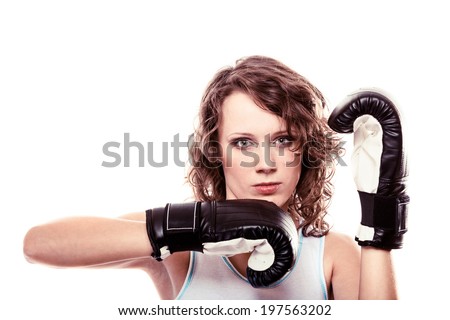 Martial arts or emancipation idea concept. Sport boxer woman in black gloves. Fitness girl training kick boxing showing her power domination. Isolated on white background.