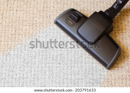 background with copy space. closeup cleaning with black vacuum cleaner hoover dirty, dusty floor beige carpet. housework.
