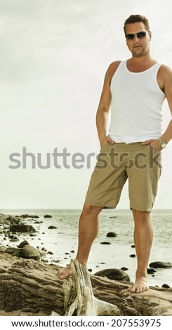 Happiness summer vacation and people concept. Fashion portrait of handsome man in sunglasses on the beach landscape