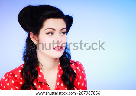 Retro style. Portrait of stylish young woman o blue. Face of brunette girl with pinup hairstyle and makeup.