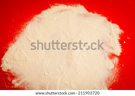 Cooking concept. Preparation for baking, bake ingredients to make a cake, wheat flour as background on red silicone mat, top view