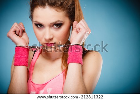 Teen crime, arrest and jail - Criminal teenager girl prisoner woman in handcuffs blue background