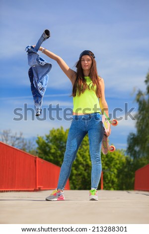 Summer sport and active lifestyle. Cool teenage girl skater with skateboard on the street. Outdoor.