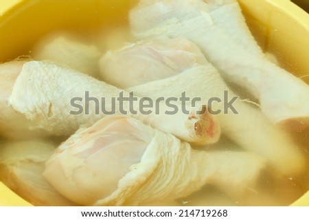 Close up raw chicken meat drumstick in water, washing cleaning and food preparing.