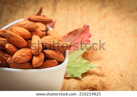 Healthy food, good for heart health.  Almonds in white bowl on wooden old rustic table background
