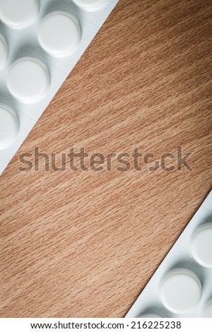 Medical background backdrop with frame border of pills tablets drugs on wooden table. Pharmacy.