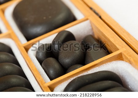 Beauty salon. Close up of black spa zen massage stones in wooden case with white blank copy space for text message. Relax concept.