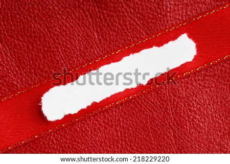 Piece scrap of white torn or ripped paper banner, blank copy space for text message on red leather background