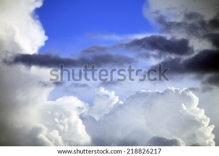 Deep blue sky background with storm clouds. Cloudy sky full of gray white thunder clouds before rain