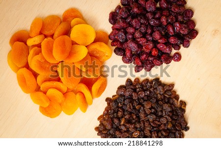 Healthy food organic nutrition. Dried dehydrated fruits raisins apricots and cranberries on wooden table