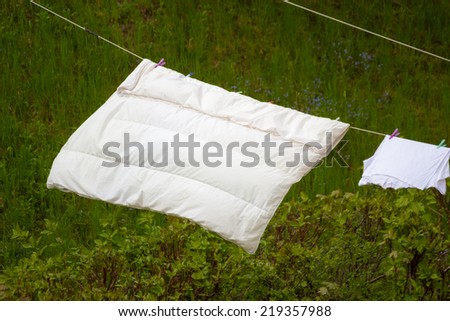 Housework. Clean wet laundry bedding hanging to dry on the line clothesline outdoor. Rural scene.