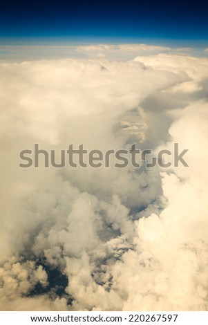 Blue white cloudy sky. View from window of airplane flying in clouds. Skyscape cloudscape. Bird\'s eye.