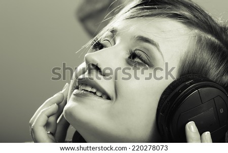 Technology, music and happiness concept - smiling girl teenage in headphones listening music. Black white color, vintage photo