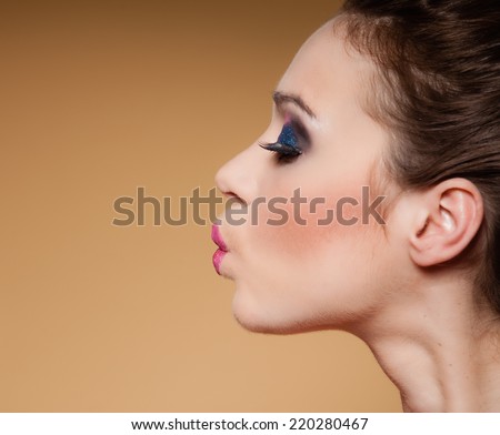 Young happy woman having fun. Face profile of pretty funny teen girl on brown
