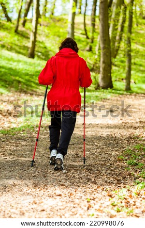 Nordic walking. Woman hiking in the forest or park. Active and healthy lifestyle.