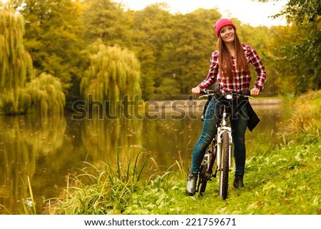 Fall active lifestyle concept,. young woman sporty casual girl relaxing in autumnal park with bicycle, outdoor