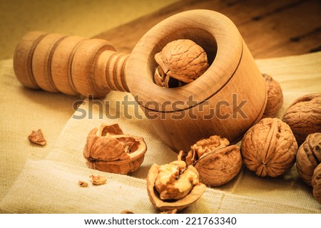Healthy food full of omega-3 fatty acids, organic nutrition. Walnut with nutcracker on rustic old table
