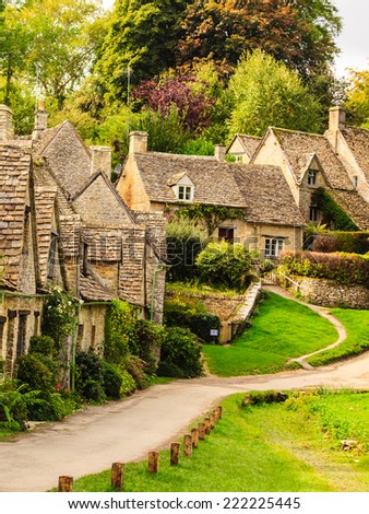 BIBURY, ENGLAND, UK - SEPTEMBER 21, 2014: Arlington Row traditional Cotswold stone cottages in Gloucestershire on September 21, 2014, England. Bibury is the most depicted village in the world.
