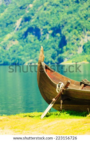 Tourism and travel. Mountains and fjord Sognefjord in Norway, Scandinavia. Old viking boat on seashore.