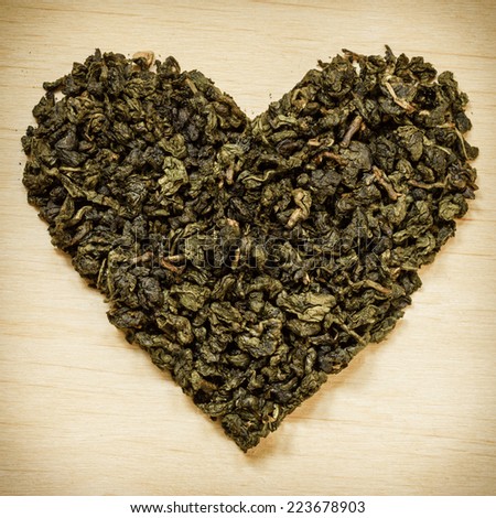 Diet healthcare concept. Green tea heart shaped on wooden surface. Healthy food drink for lower heart disease risk
