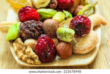 Healthy food organic nutrition. Closeup different varieties mix of dried fruits and nuts on wooden spoon.
