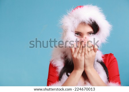 woman wearing santa claus costume clothes covered her face by fur on blue background