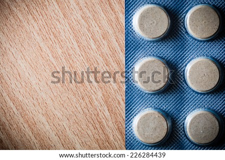 Medical background backdrop with pills tablets drugs on wooden table. Pharmacy.