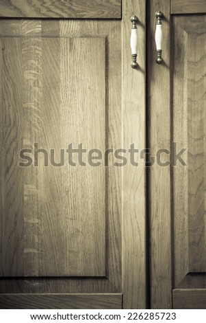 Furniture part. Retro style. Closeup of vintage wooden kitchen cabinet or cupboard with metal handles as background.