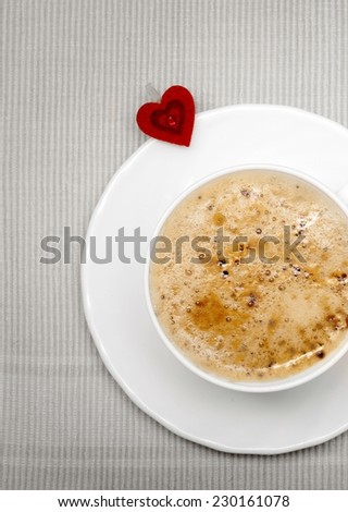 White cup of hot beverage drink coffee cappuccino latte with homemade gingerbread cake star with icing and blue decoration and red heart symbol love. Christmas. Holiday concept.
