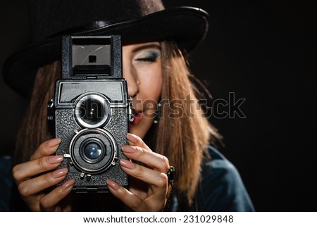 Steampunk. Retro woman with old vintage camera studio shot grunge dark background