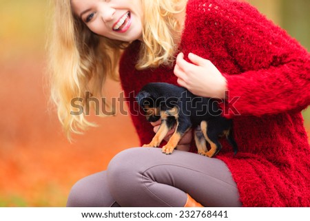 Pets and people, pet adoption. Woman playing with her little dog pet outdoor, hugging lovingly embraces her puppy.