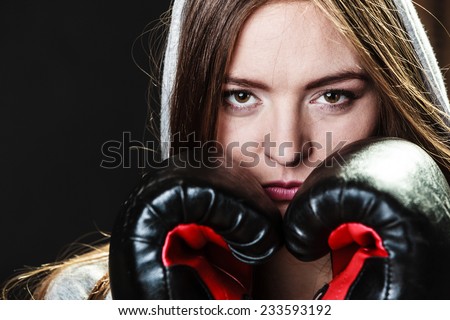Martial arts or self defense concept. Sport boxer woman in gloves. Fitness girl training kick boxing on black background