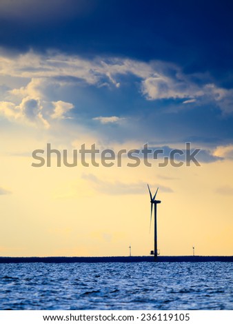 wind turbines power generator farm for renewable energy production along coast baltic sea near Denmark at sunset or sunrise. Alternative green energy ecology.