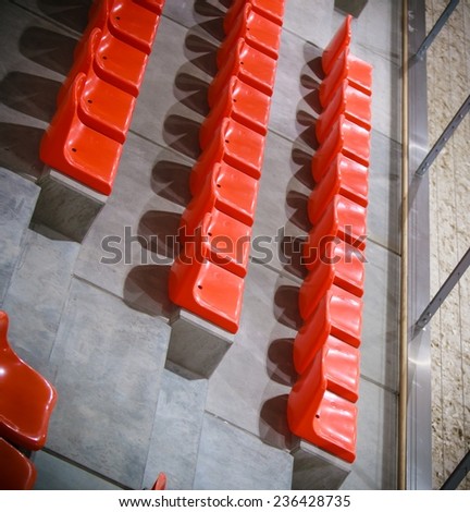 Closeup of red sport stadium seats. Empty stand. Team sport and football supporters fans.