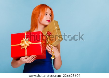 People celebrating holidays, love and happiness concept - happy red hair girl with gift boxes studio shot on blue background