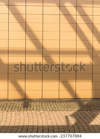 Shadows on empty orange tiled wall with blank copyspace copy space as background. Architecture detail. Real.