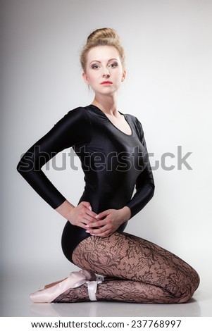 modern style beautiful woman ballet dancer sitting on floor full length studio picture gray background