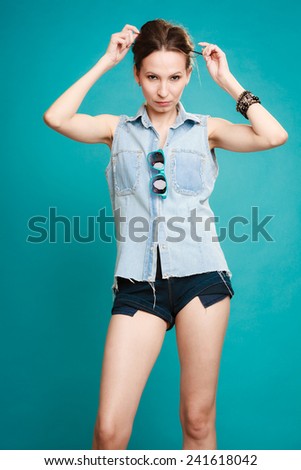 Vacation and summer fashion. fashionable girl in jeans shirt shorts on blue