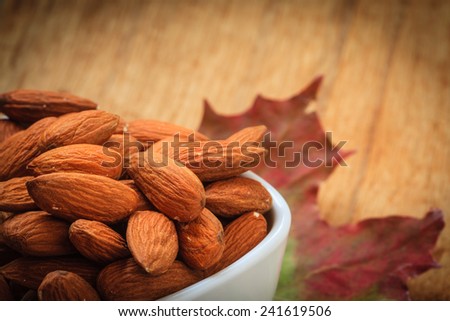 Healthy food, good for heart health.  Almonds in white bowl on autumnal background