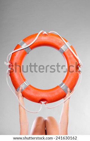 Accident prevention and water rescue. Life buoy ring lifebelt in female hands studio shot gray background