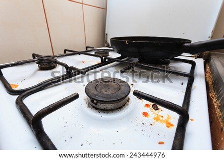 Housework, hygiene and cleaning concept. Dirt at home. Dirty filthy gas stove with used kitchen cooking stuff, frying pan