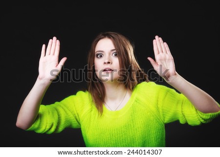 Scared. young woman teen girl making stop gesture sign with hands palms on black.