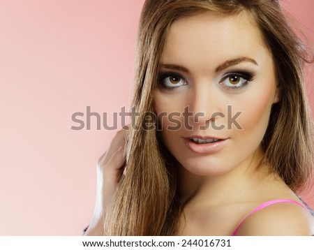 portrait beautiful woman face with makeup and long blond hair on red
