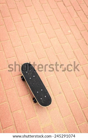 Sport equipment. Lone skateboard deck on concrete red paving stone background with copy space