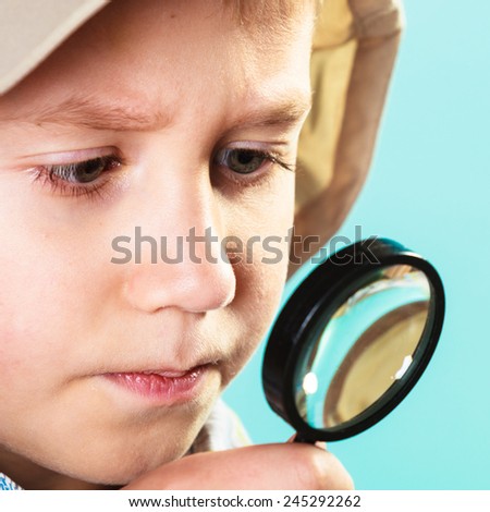 Children development, education concept. Child looking through a magnifying glass loop, closeup