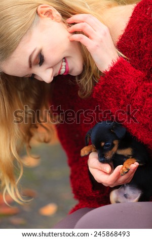 Pets and people, pet adoption. Woman playing with her little dog pet outdoor, hugging lovingly embraces her puppy.