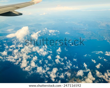 Blue white cloudy sky and plane. View from window of airplane flying in clouds over Norway Scandinavia. Skyscape cloudscape.